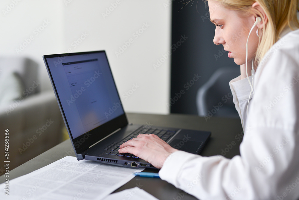 Woman looks intently at her laptop screen. Woman looks intently at her laptop screen.