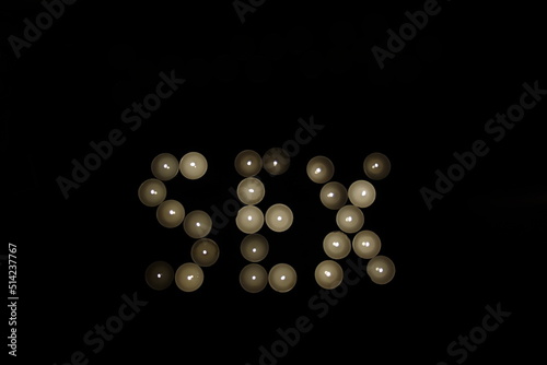 word sex written with burning candles isolated on black background