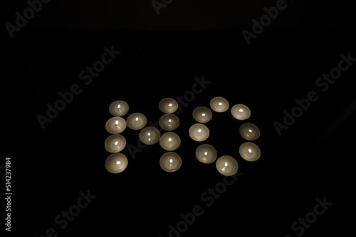 word no written with burning candles isolated on black background