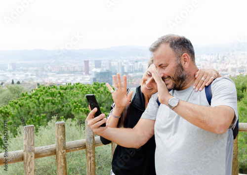 Photo Middle aged couple making a video call with their friends and family