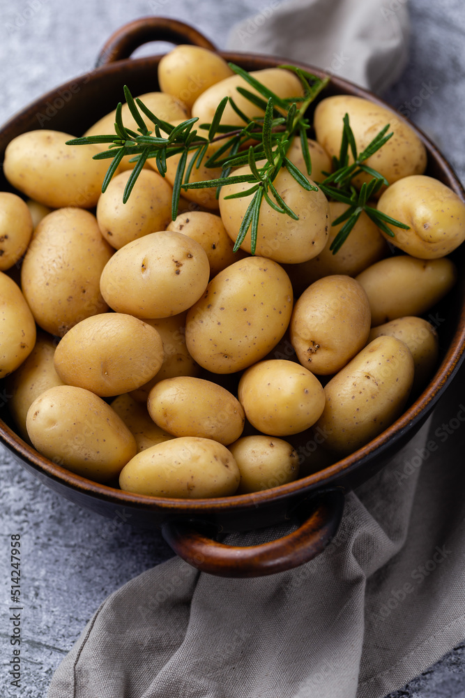 Raw small potatoes in a cast iron skillet on a beton background. Raw small potatoes in a cast iron skillet on a beton background.