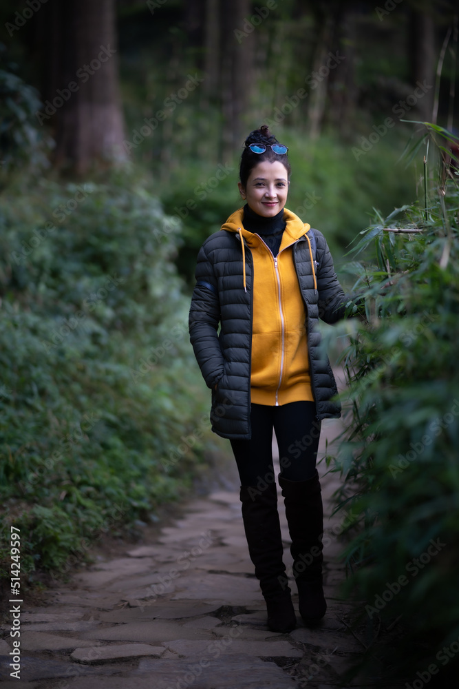 indian girl Walking in the forest in a yellow hoodie in Darjeeling in India indian girl Walking in the forest in a yellow hoodie in Darjeeling in India