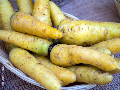 Yellow carrots in a basket on a wooden table