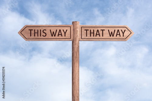 This way or That Way concept. Words in opposite directions on signpost with sky background