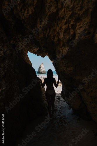 Woman admiring seashore from cave in summer