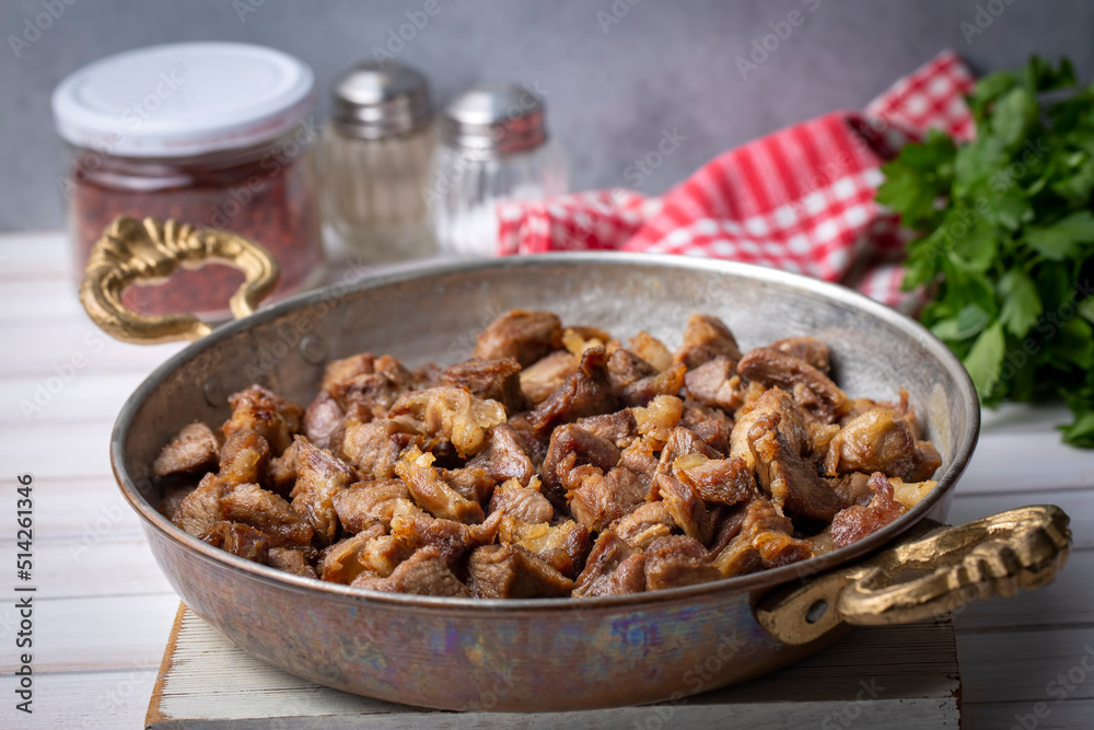 Muslims Traditional Sacrifice holiday food lamb, Turkish roasted meat in copper pot on table top. Turkish Kavurma. (Turkish name; Kurban kavurma) Muslims Traditional Sacrifice holiday food lamb, Turkish roasted meat in copper pot on table top. Turkish Kavurma. (Turkish name; Kurban kavurma)