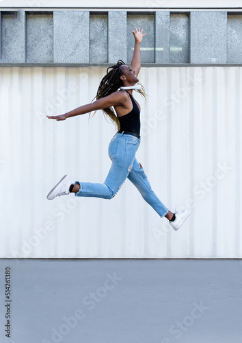 Retrato de una chica joven afroamericana saltando y divirtiendose. Estilo urbano photo