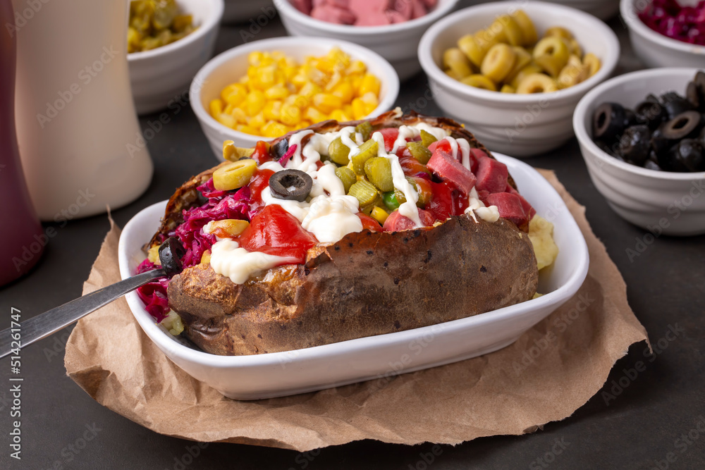 Kumpir, Turkish baked potato with cheese, corn, sausage, ketchup, mayonnaise and olives. This kumpir is traditional turkish food