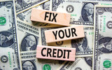 Fix your credit symbol. Concept words Fix your credit on wooden blocks on a beautiful background from dollar bills. Business, finacial and fix your credit concept. Copy space.