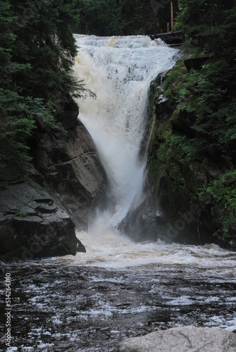 Szklarki waterfall in the Karkonosze Mountains, Poland. A view of a waterfall surrounded by a forest on a cloudy day. photo