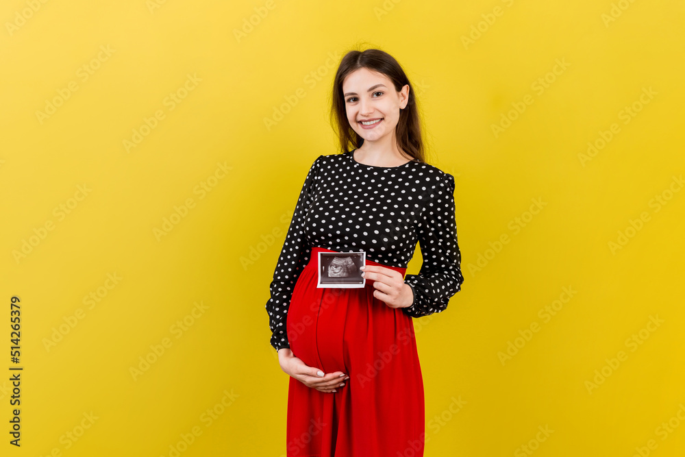 Cute Pregnant Lady Posing With Baby Sonography Photo Near Colored background. Concept of pregnancy, gynecology, medical test, maternal health Cute Pregnant Lady Posing With Baby Sonography Photo Near Colored background. Concept of pregnancy, gynecology, medical test, maternal health