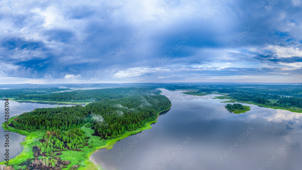 Big lake with green shores with morning fog in dawn, aerial landscape. Recreation concept. Aerial view