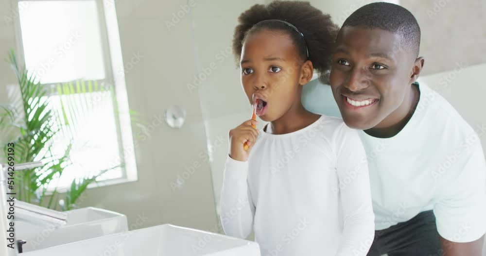 Vertical video of african american father and daughter brushing teeth Vertical video of african american father and daughter brushing teeth