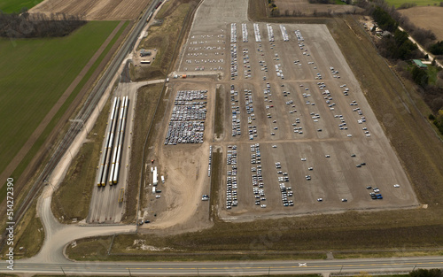 A drone view beside an auto distribution and homologation center. Autotrack train cars sit beside the large center, next to a railway. photo