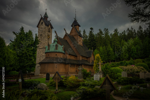 Wooden church with stone tower in cloudy spring day in Karpacz town