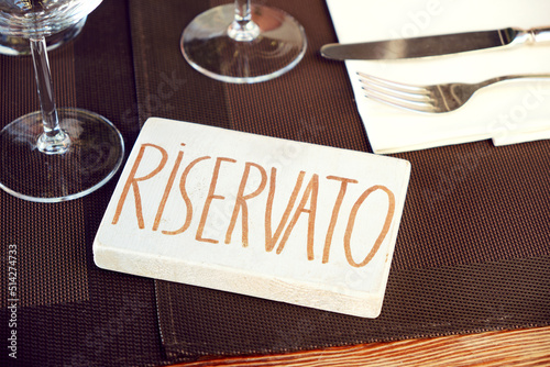 Reserved sign in Italian language on a table in restaurant