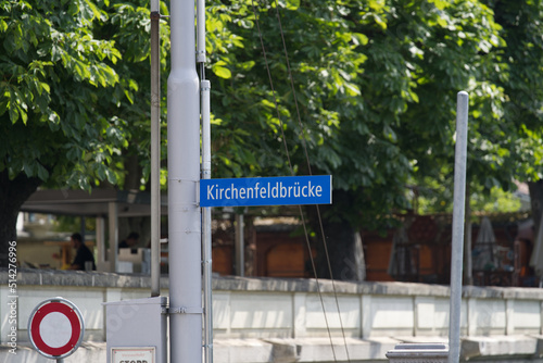 Blue and white road sign with text of bridge Kirchenfeld (German, translation is Church Field) at the old town of Bern on a sunny summer day. Photo taken June 16th, 2022, Bern, Switzerland. 