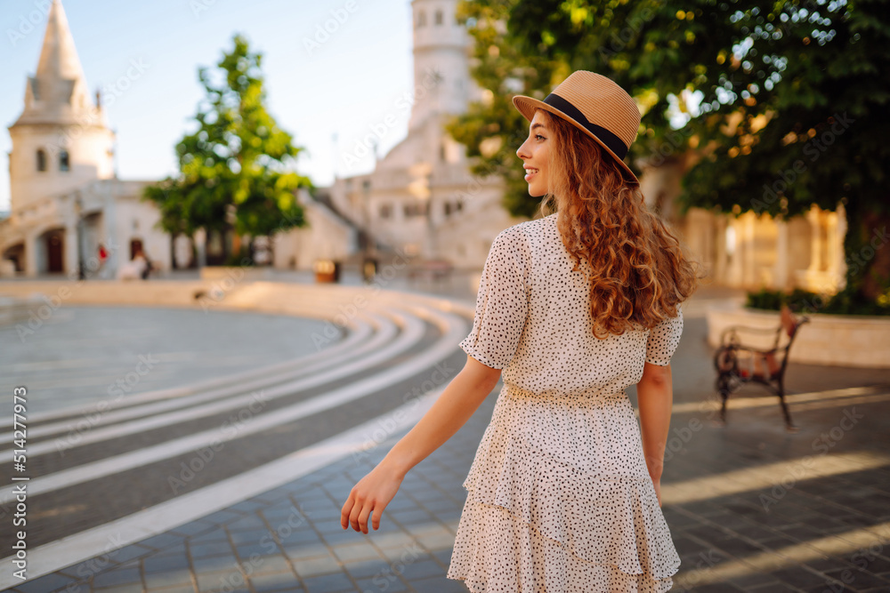 Beautiful young woman posing on the background of the castle. Tourism, relax, youth, nature.