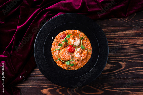 classic italian risotto with shrimps and prawns on a wooden background