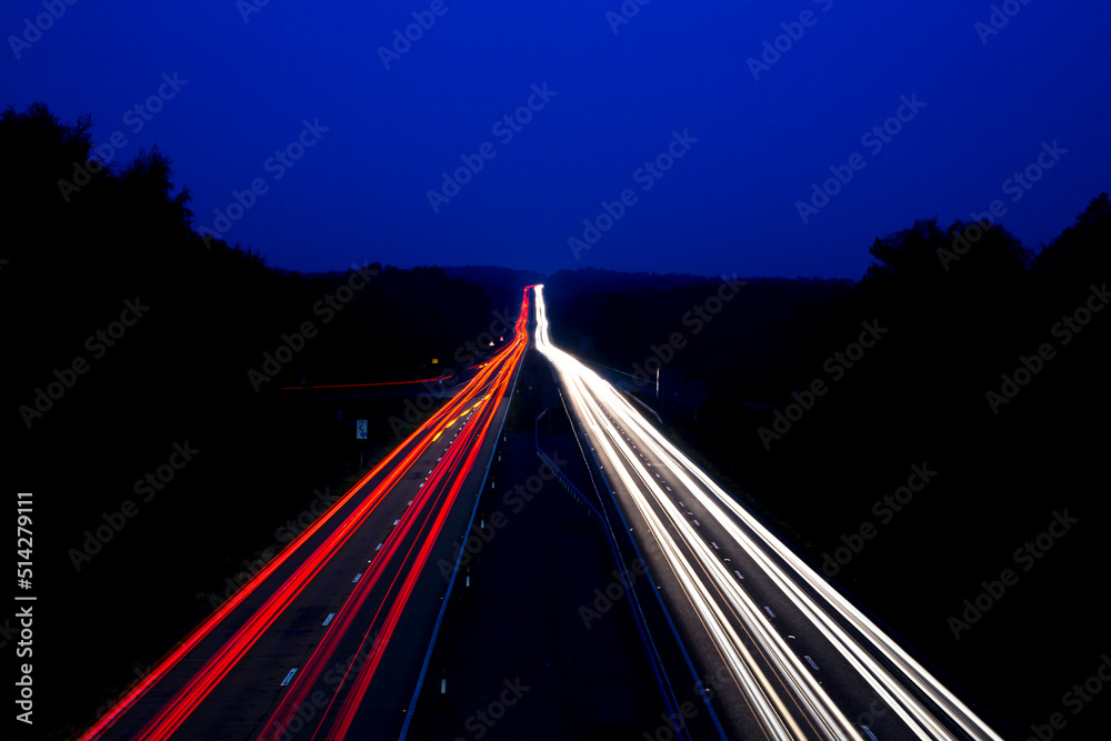 A shot of cars on both sides of the carriageway disappearing over the horizon - obrazy, fototapety, plakaty 