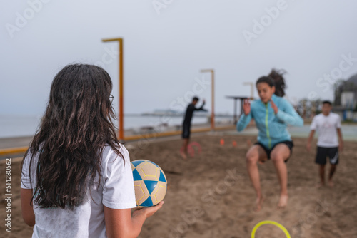 Two women training to play footvolley on the beach