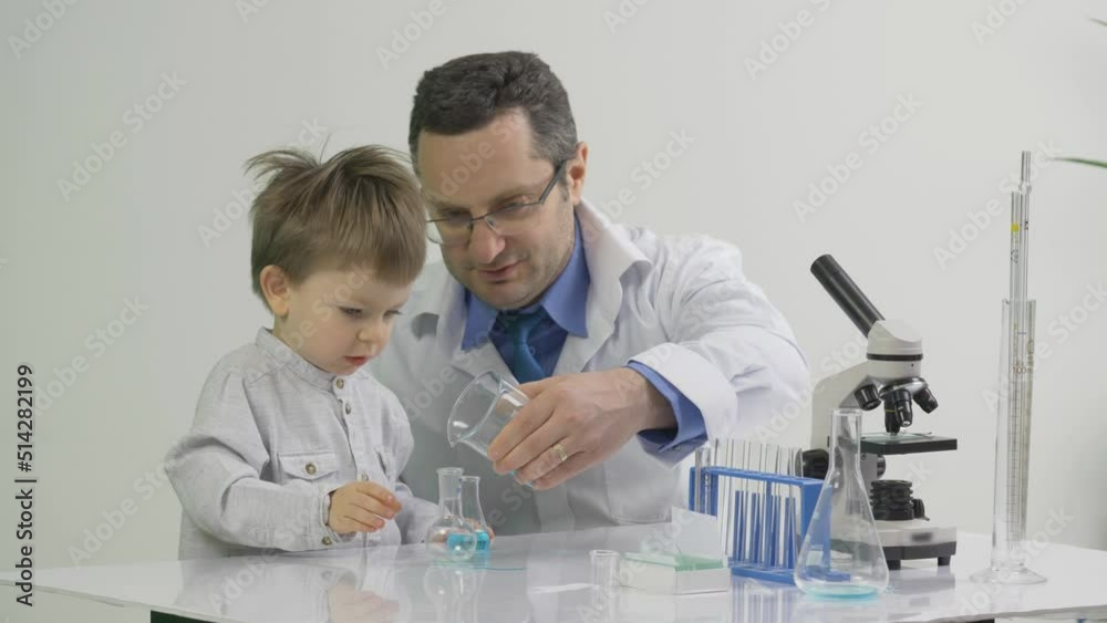 Father chemist shows his son some laboratory experiments Father chemist shows his son some laboratory experiments