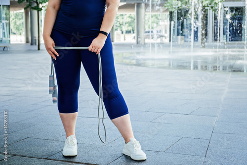 Faceless Plus size curvy happy young woman with skipping rope outdoors. Curvy Woman with Skipping Rope © irissca