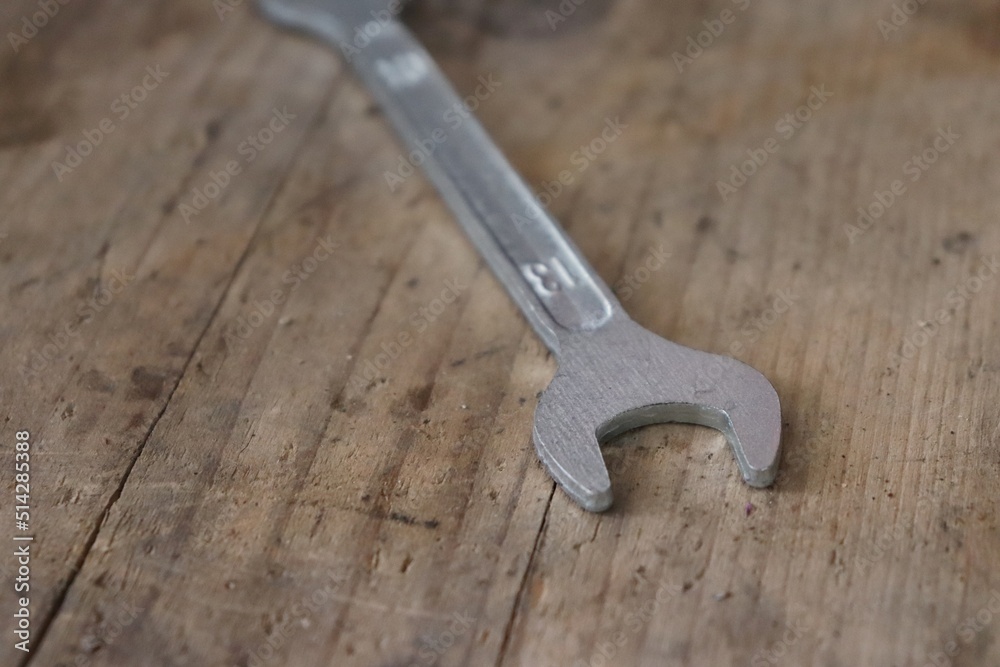 Fixed wrench on a brown wooden prank Fixed wrench on a brown wooden prank