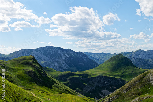 Fototapeta Naklejka Na Ścianę i Meble -  Zelengora mountains in Sutjeska National Park. Small pond in the valley surrounded by mountains. Hiking life. Travel and adventurous. Camping by the lake. Scenic and beautiful view. 
