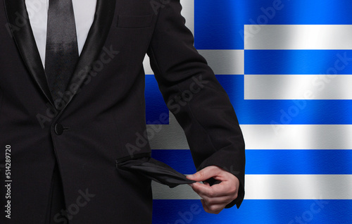 Poverty, financial difficulties, bad economy, tax or social problem in Greece concept. Businessman with empty pocket on Greek flag background.