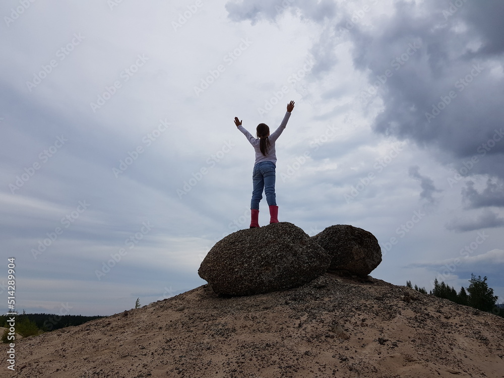 Little child outdoors with hands up on sky background. Freedom, travel and holiday concept Little child outdoors with hands up on sky background. Freedom, travel and holiday concept
