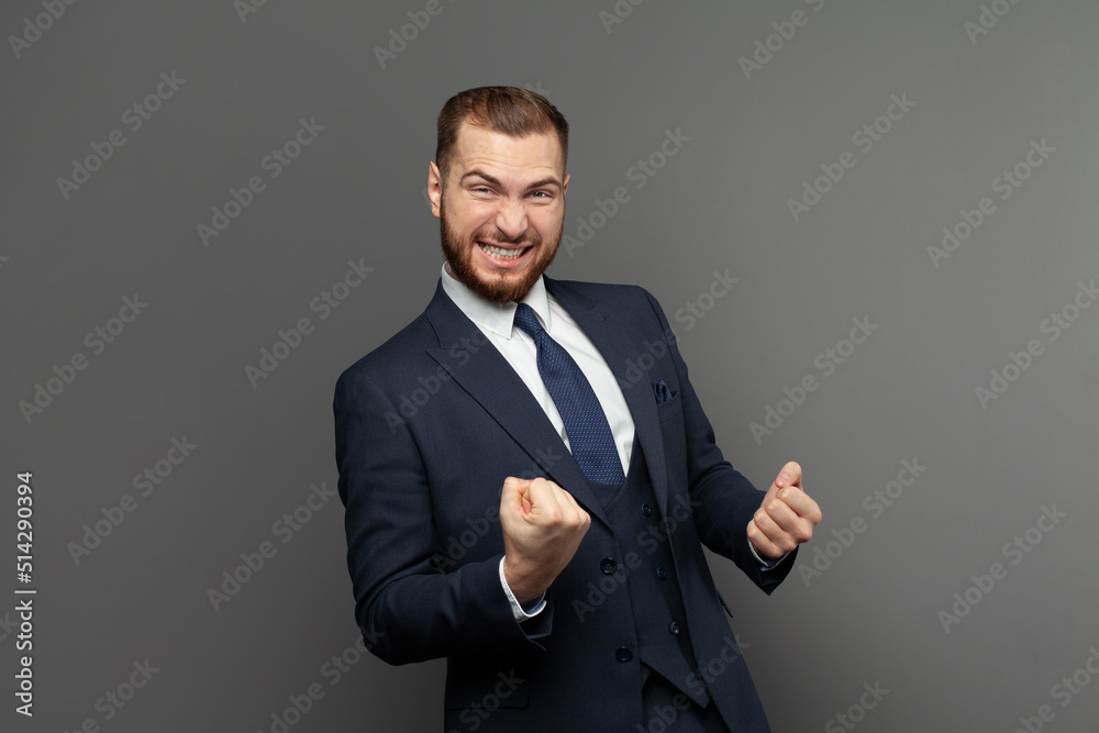 Happy excited businessman laughing against grey studio wall background portrait. Business win, fun and success concept Happy excited businessman laughing against grey studio wall background portrait. Business win, fun and success concept