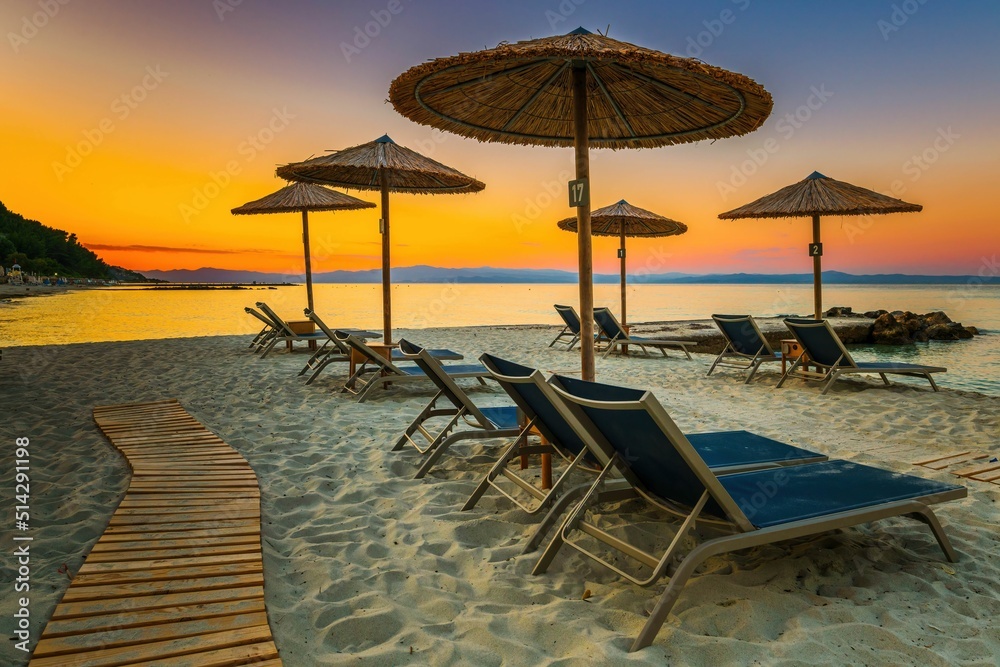 Parasolki na plaży o zachodzie słońca w Grecji