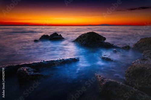Widok skał oblewanych przez morze o wschodzie słońca przy kolorowym niebie © Michal45