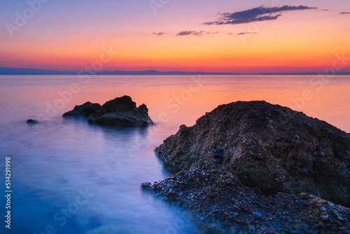 Fototapeta Naklejka Na Ścianę i Meble -  Widok skał oblewanych przez morze o wschodzie słońca przy kolorowym niebie