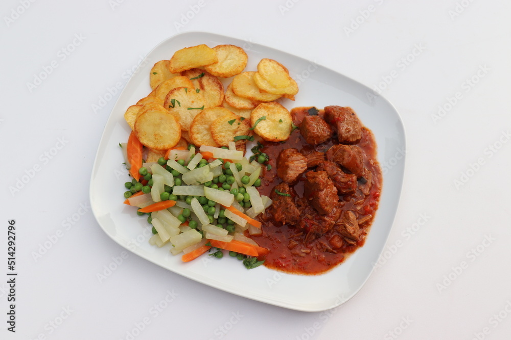 Fleischgericht: Gulasch mit Bratkartoffeln und Gemüse.