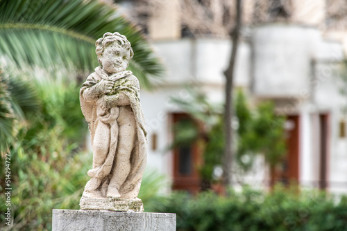 Baroque sculpture of a child in a park in Trani, Italy