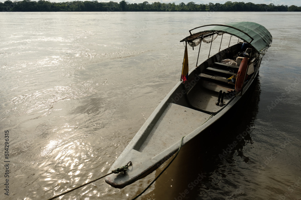 An empty canoe tied along the banks of the amazon river