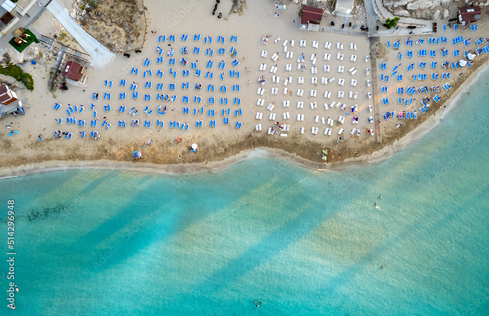 Beach umbrellas in a row at fig tree bay beach Protaras Cyprus. Summer vacations holiday resort.
