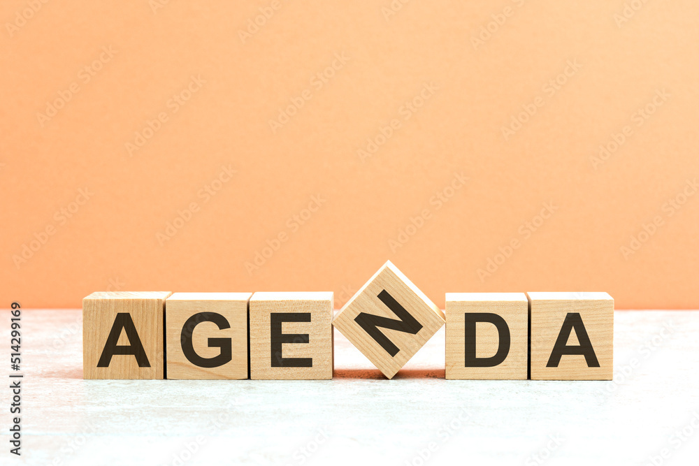 Obraz premium AGENDA text on a wooden blocks, orange background