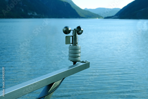 modern device anemometer over alpine lake controls parameters, meteorological equipment measures speed of movement of air masses, humidity levels, atmospheric pressure, wind strength and direction