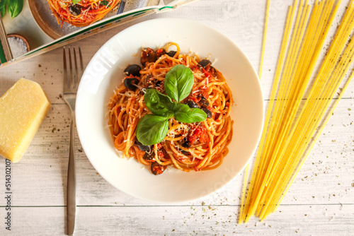 A plate of delicious spaghetti pasta with basil tomatoes and parmesan cheese