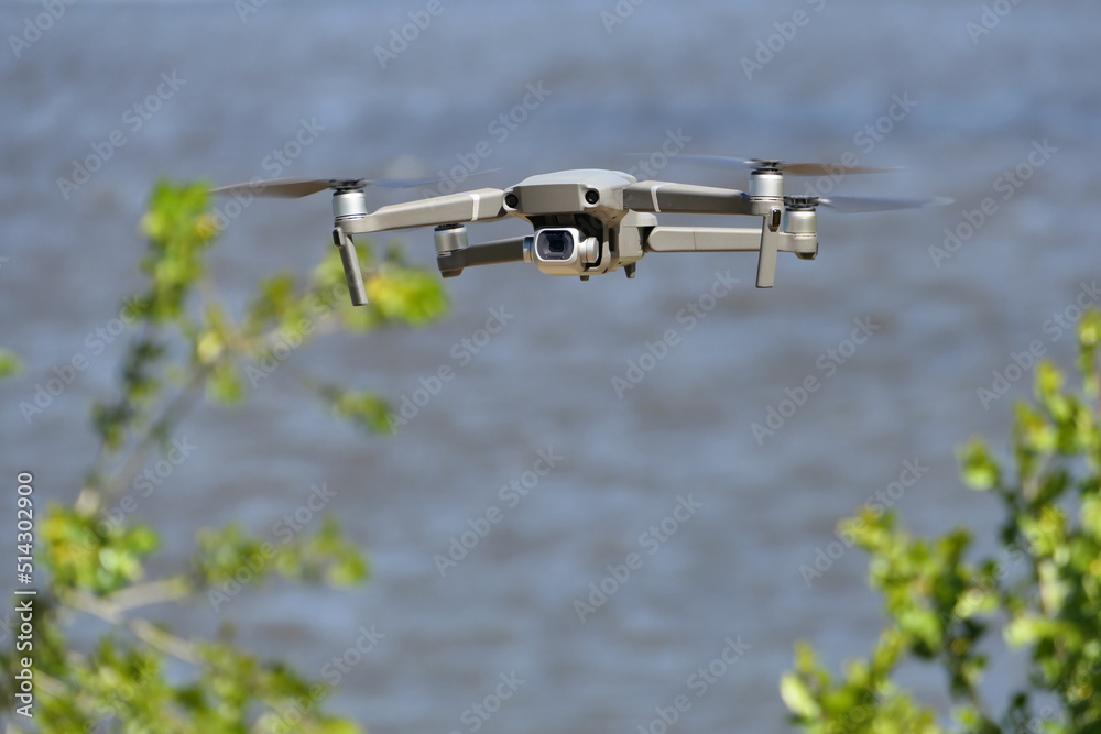 Gray quadcopter in flight. Photo-video aerial photography. Gray quadcopter in flight. Photo-video aerial photography.