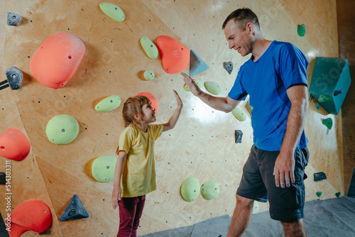 Φωτογραφία Rock climber father and daughter climbing in a modern gym