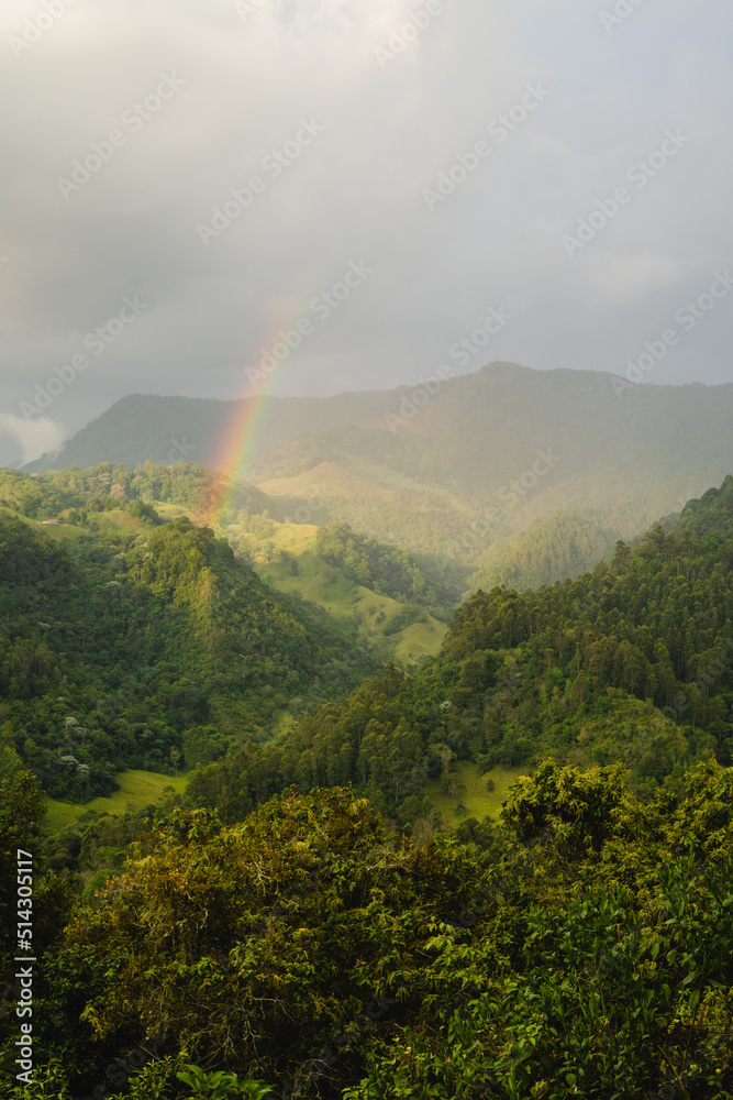 colombian landscape, cloudy mountains with rainbows, in the coffee region, vertical photo