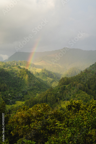 colombian landscape, cloudy mountains with rainbows, in the coffee region, vertical photo