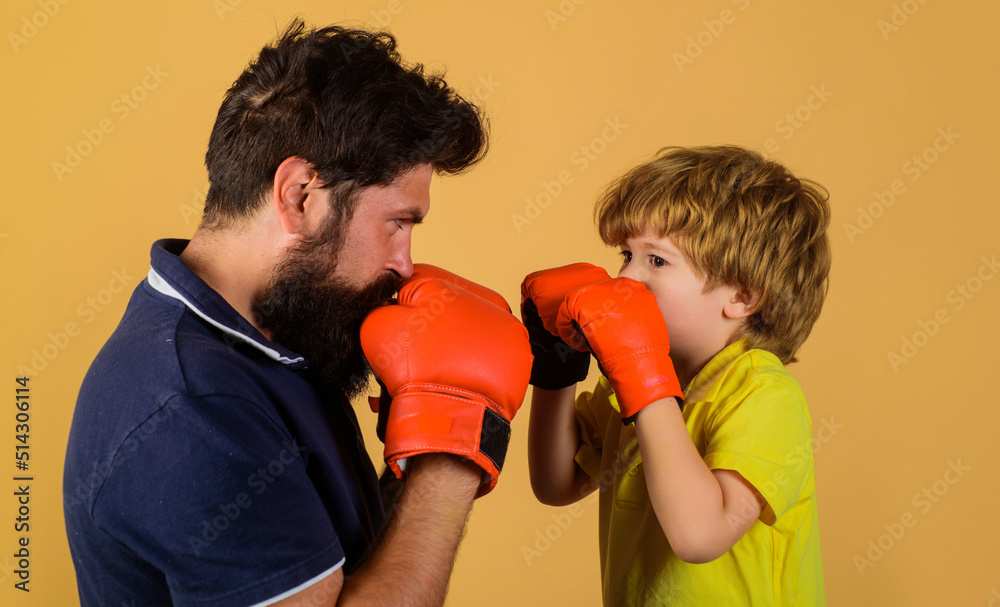Child boy in boxing gloves training with coach. Punching knockout. Father and son in sportswear. Child boy in boxing gloves training with coach. Punching knockout. Father and son in sportswear.