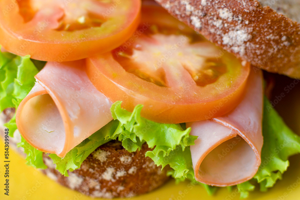 Wholemeal bread sandwich with ham, lettuce and tomato, healthy.