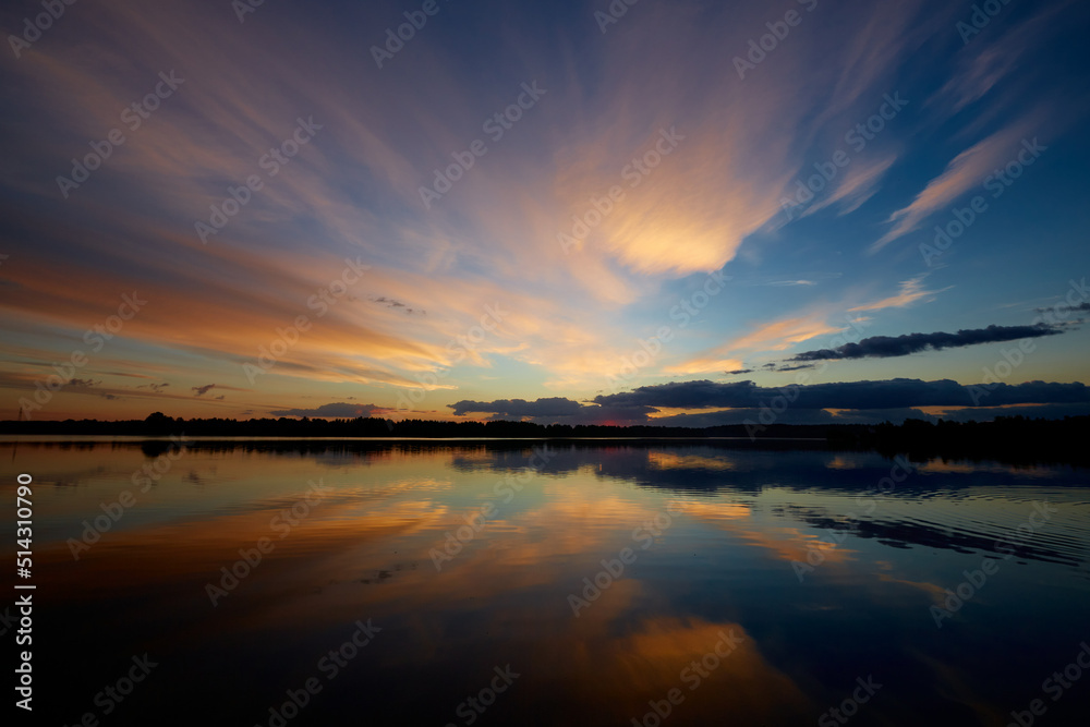 Aerial panoramic seascape - rising sun over calm water with cloudy reflections and beautiful glowing colors
