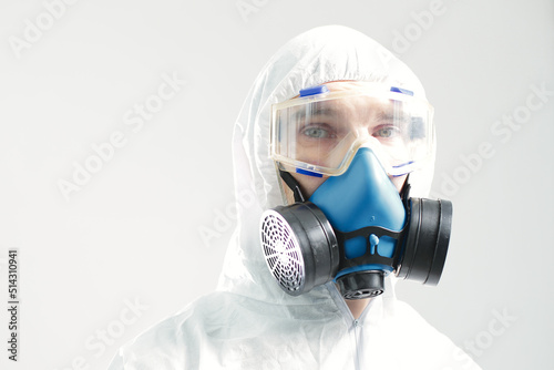 Man in protective suit goggles and respirator photo